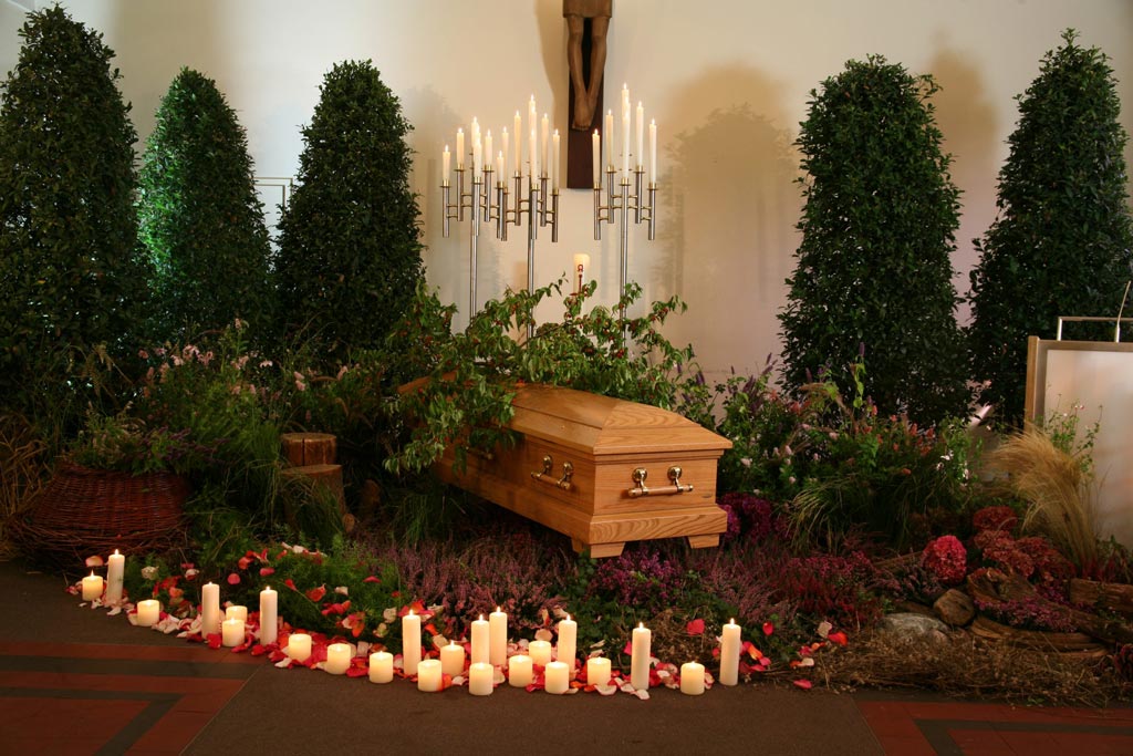 Sarg mit Pflanzen und Kerzen - Bestattungsinstitut Schmidt-Peil