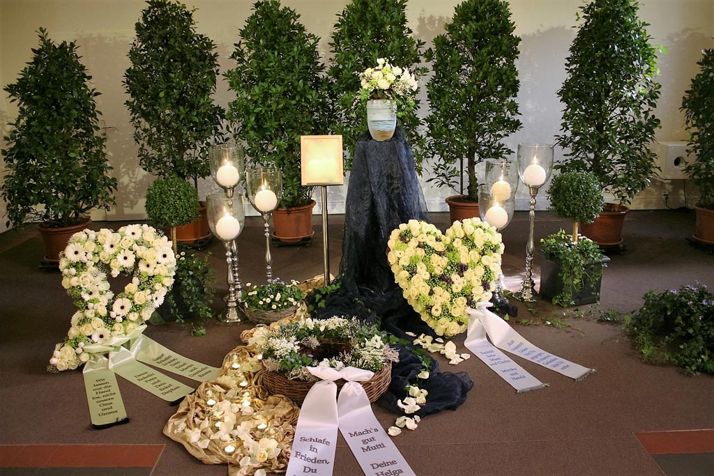 Blumengestecke vor einer Urne - Bestattungsinstitut Schmidt-Peil