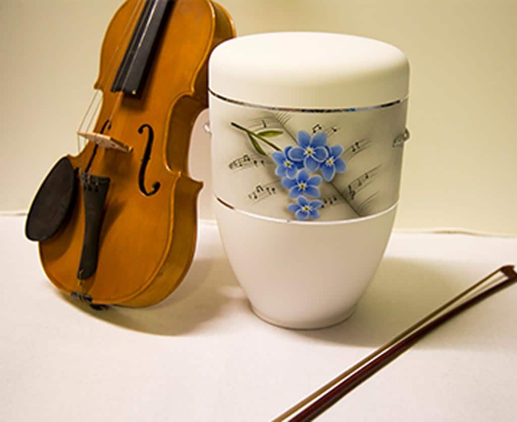 Geige und personalisierte Urne mit Verzierung Noten und Blüten - Bestattungsinstitut Schmidt-Peil
